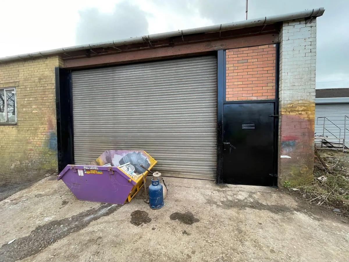 Industrial unit exterior with freshly sprayed dark roller shutter door and entry door