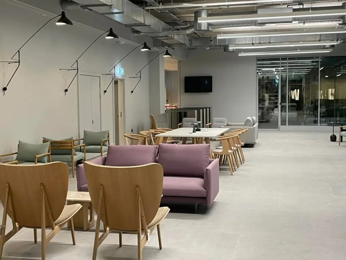 Modern commercial lounge space with designer furniture pendant lights and freshly painted grey walls